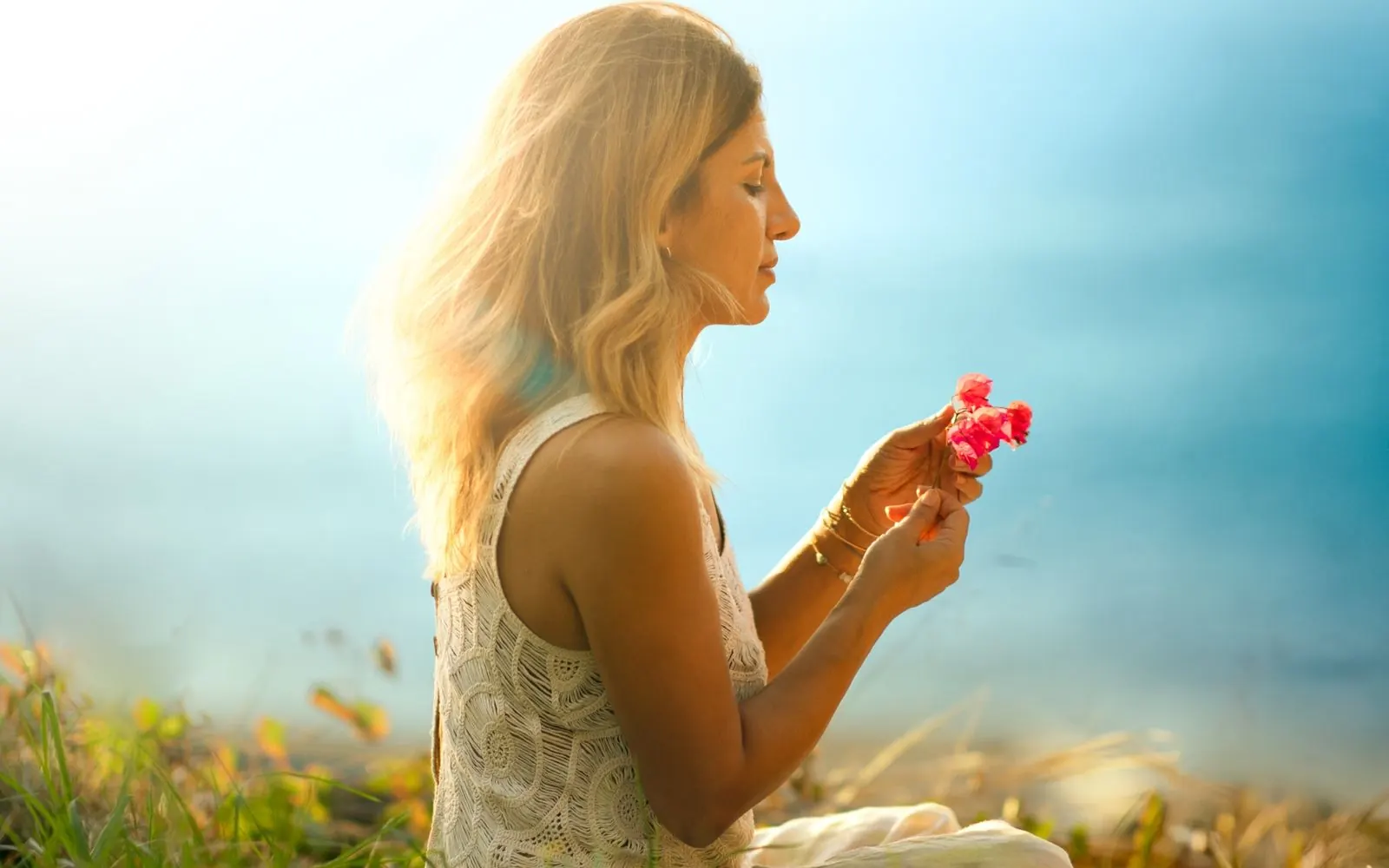 Blossoms in a hand on a meadow above the sea, retreat on Madeira